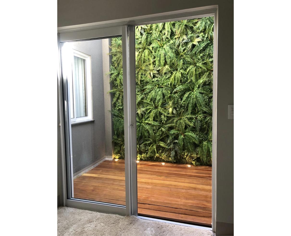 Jardim vertical iluminado em área externa residencial