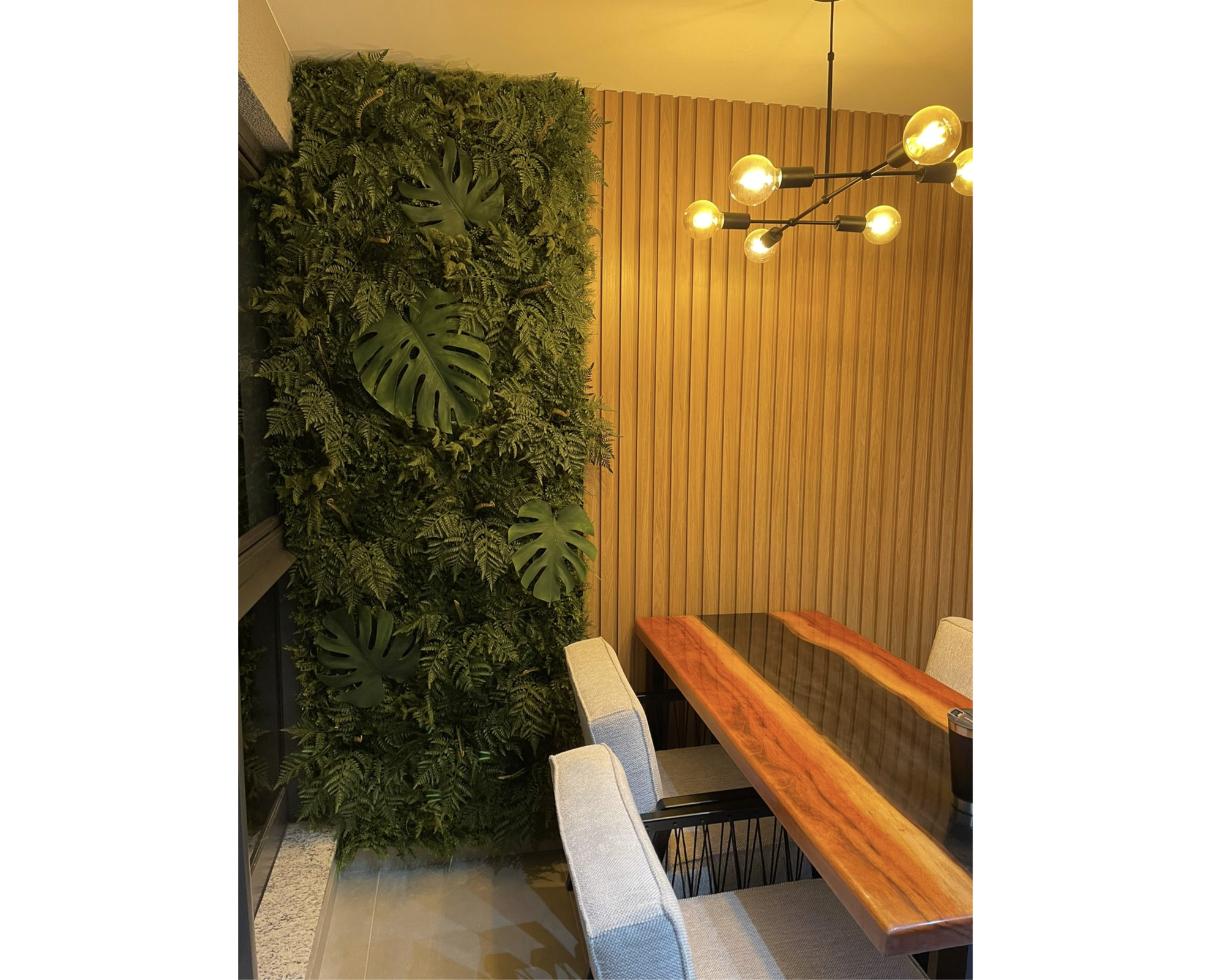 Jardim vertical ao lado de painel ripado em sala de jantar
