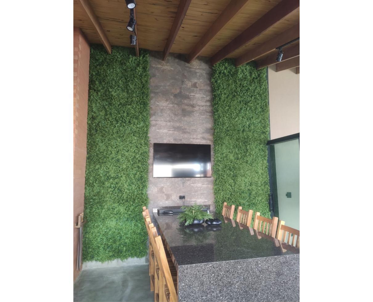 Dois painéis verdes em área gourmet com mesa central