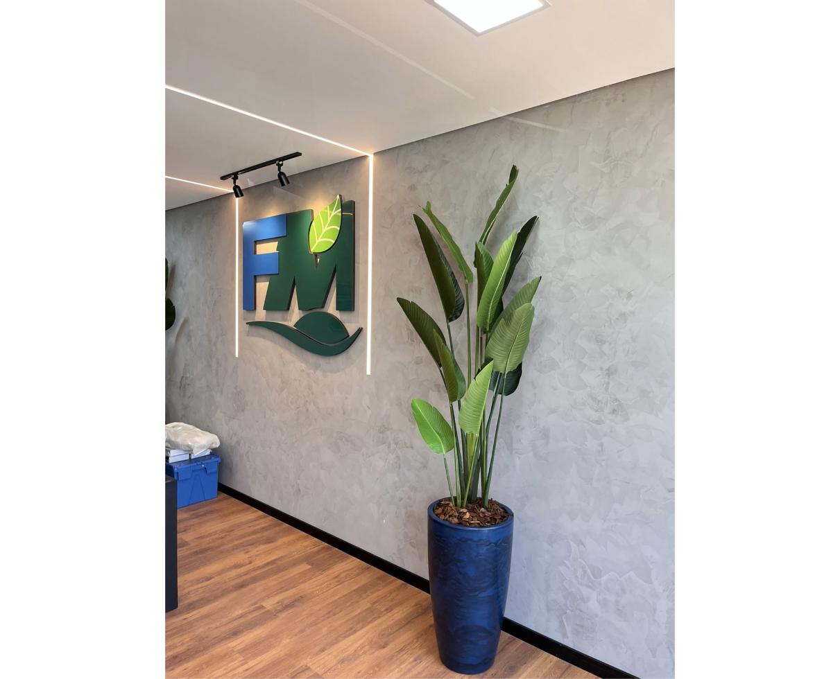 Planta tropical em vaso azul alto em ambiente comercial